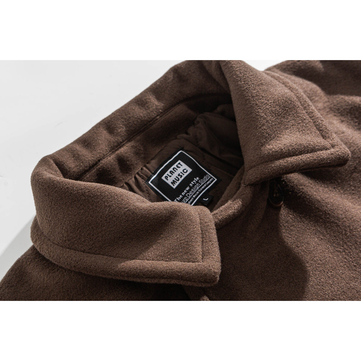 Close-up of the brown coat's wide collar and inner neck label.