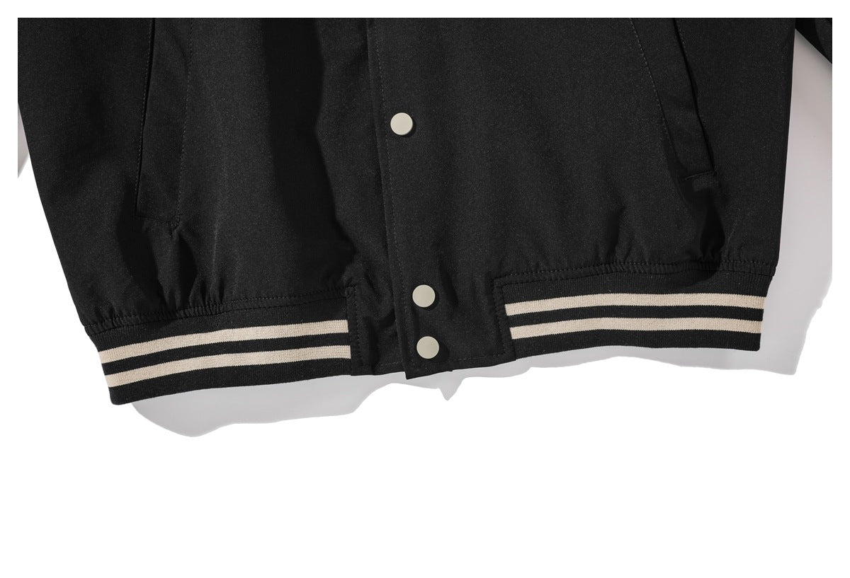 Close-up of the black jacket's lower snap placket and striped ribbed hem.