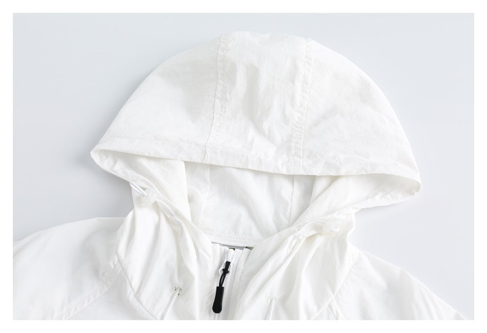 Close-up of a white jacket's hood, neckline, and front zipper pull.