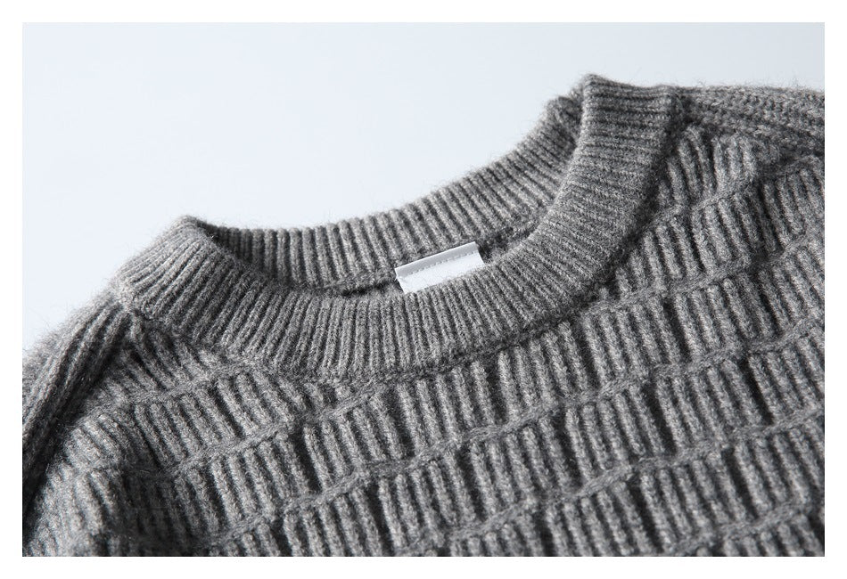 Close-up of the gray sweater's ribbed crew neckline and raised textured knit; a small blank-looking label is visible.