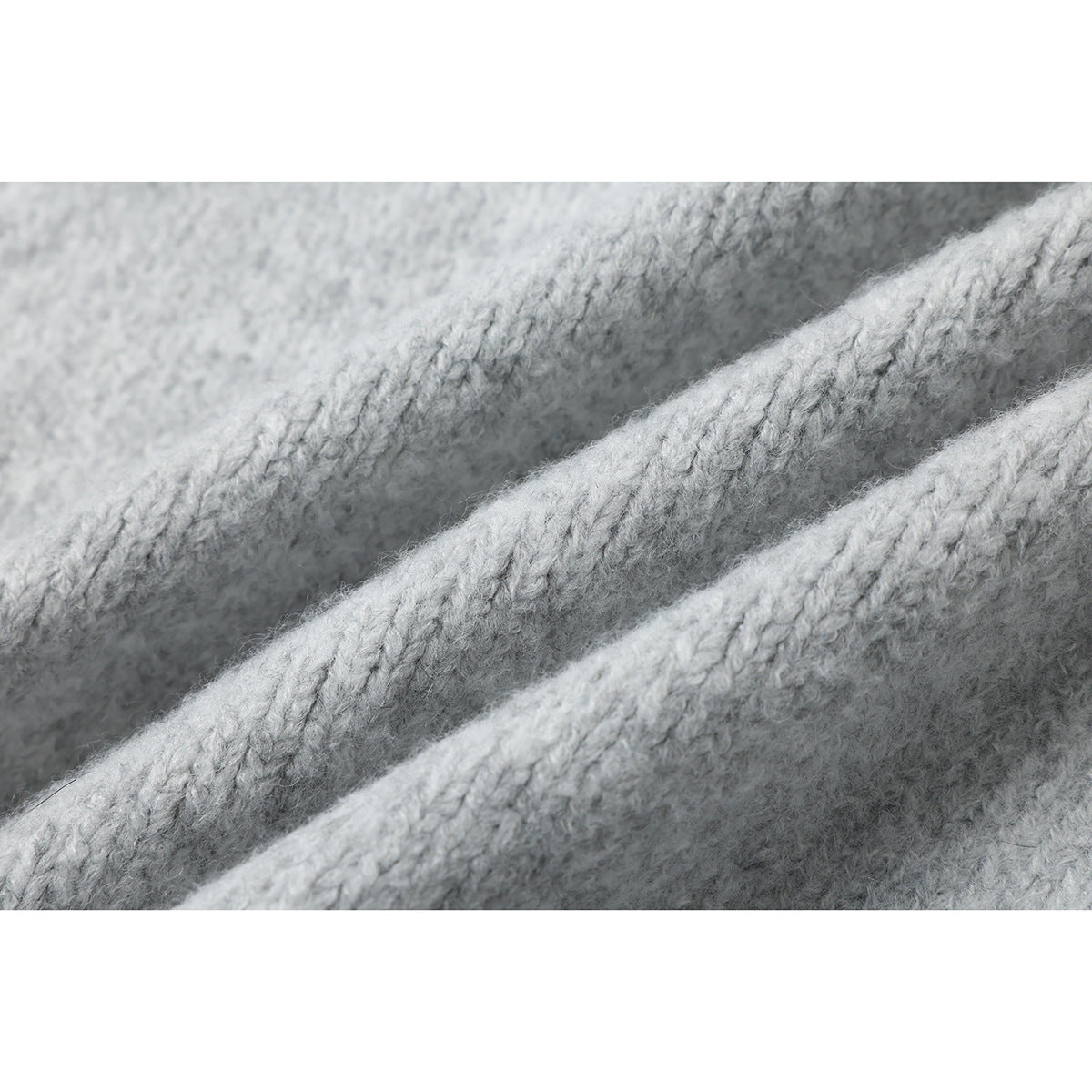 Extreme close-up of the light gray knit fabric's textured stitches.