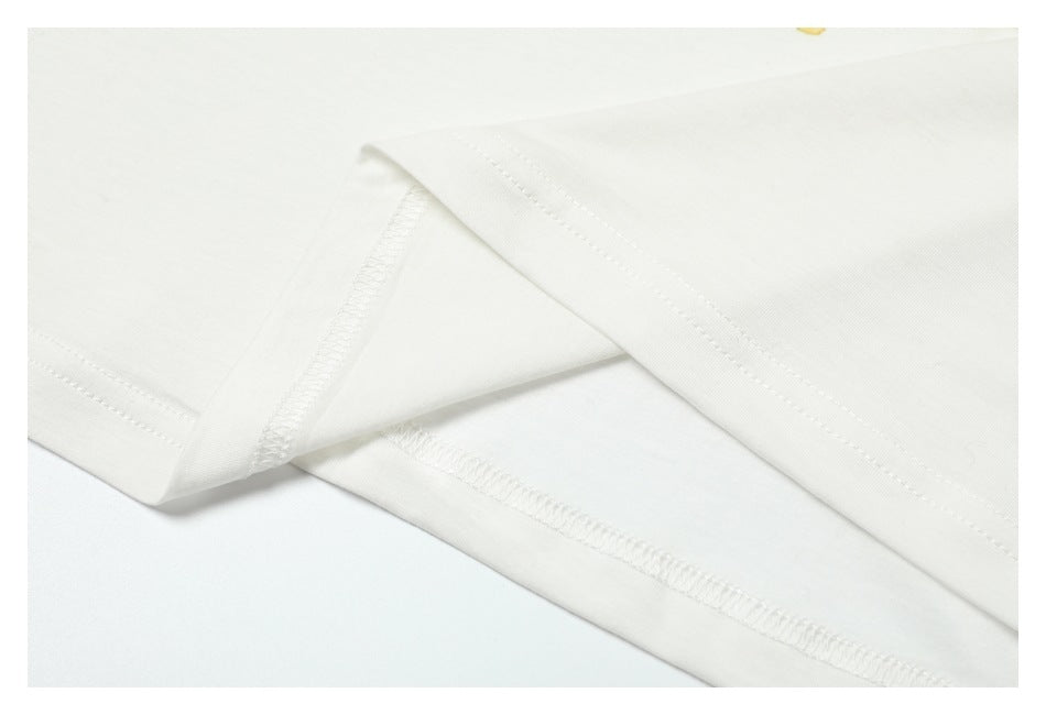 Close-up of white T-shirt fabric showing folded edges and stitched seams.