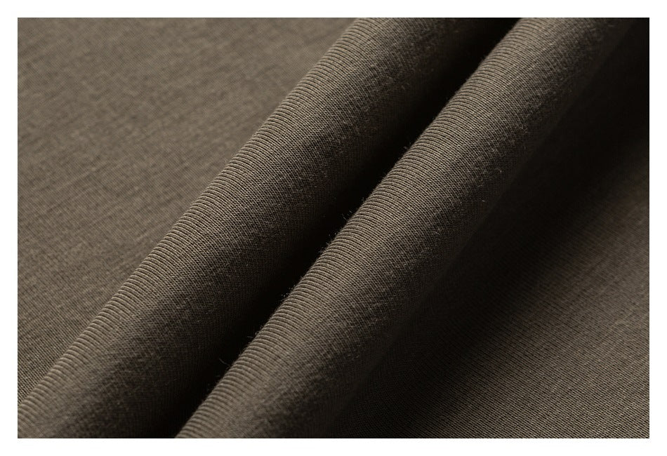 Close-up of dark brown-gray knit fabric folded to show its fine ribbed texture.