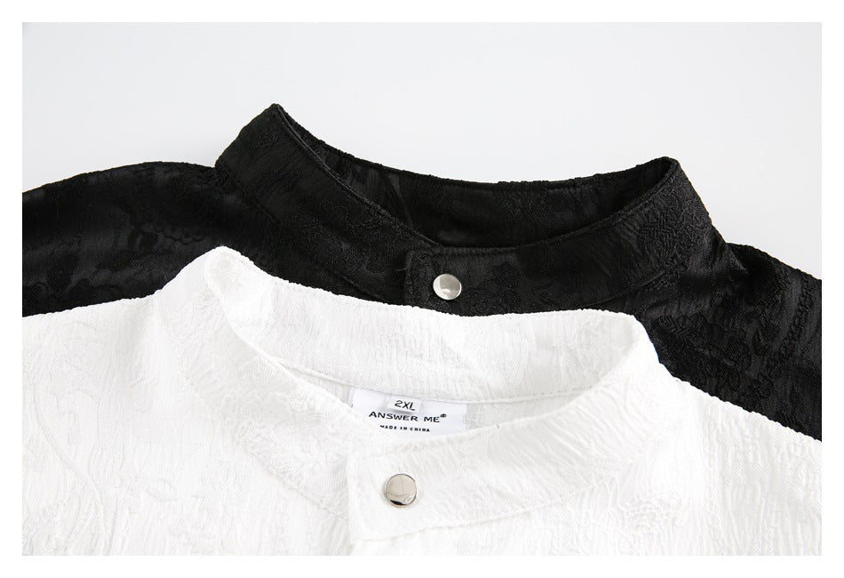 Close-up of black and white shirt collars with snap buttons; the white shirt's neck label is visible.