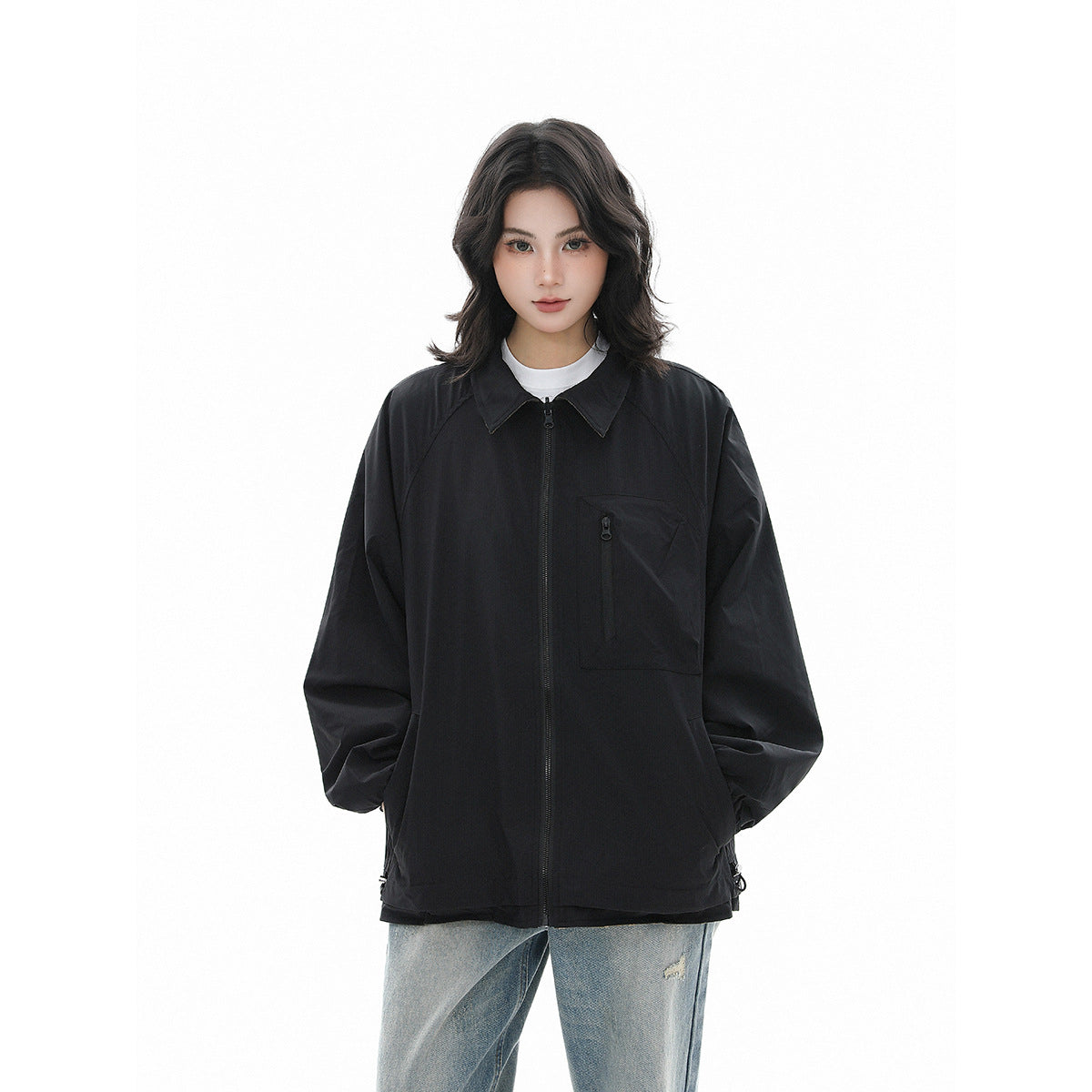 Model wearing an oversized black zip-front jacket with a pointed collar, gathered cuffs, and a zippered chest pocket.