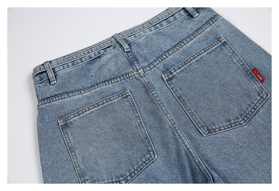 Upper back view of faded blue jeans with two stitched pockets, belt loops, and a small red side tag.