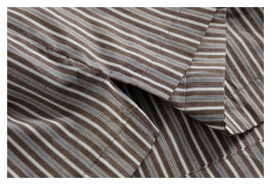 Close-up of overlapping striped shirt panels and stitched seams.