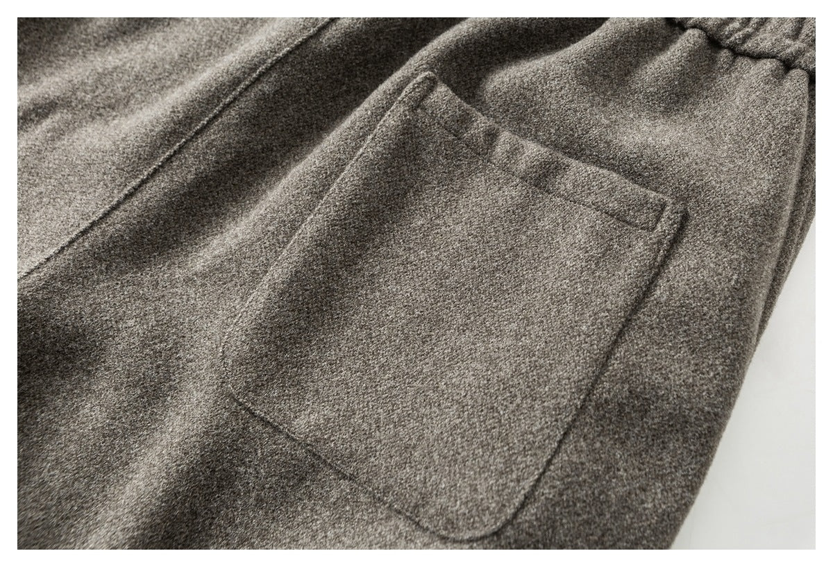 Close-up of a rectangular patch pocket sewn onto gray pants.