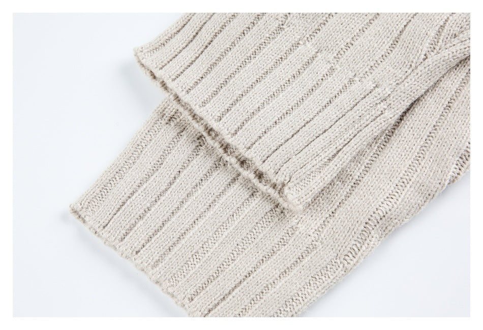 Close-up of the cream garment's ribbed knit hem, with the edge folded over.