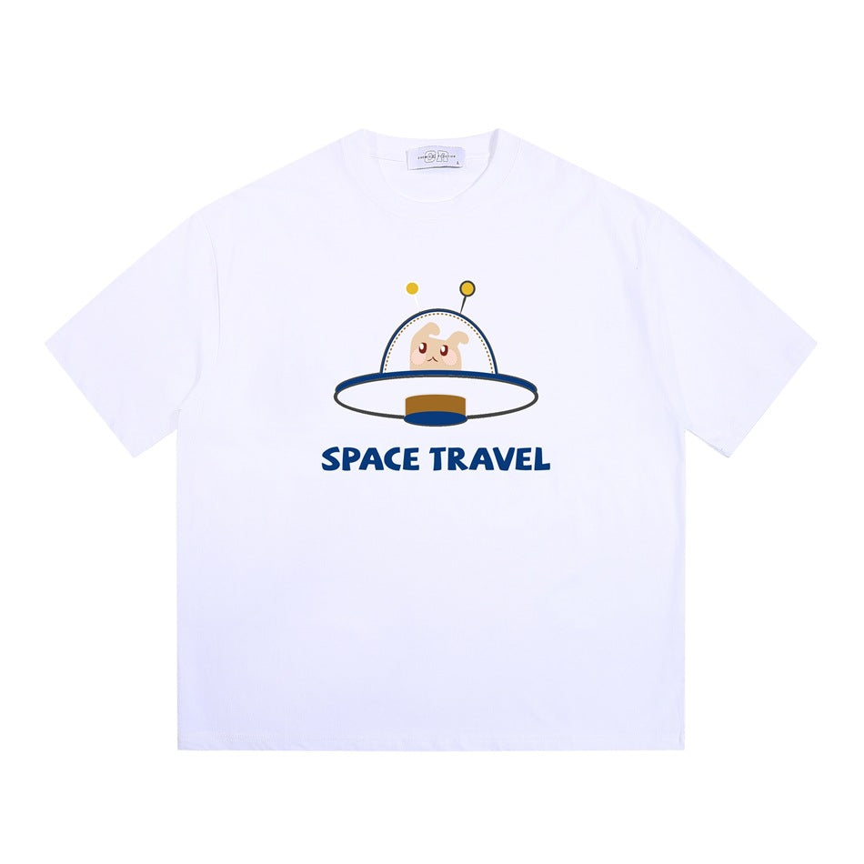 White short-sleeve crew-neck T-shirt with a cartoon UFO creature graphic and blue 'SPACE TRAVEL' text, flat lay