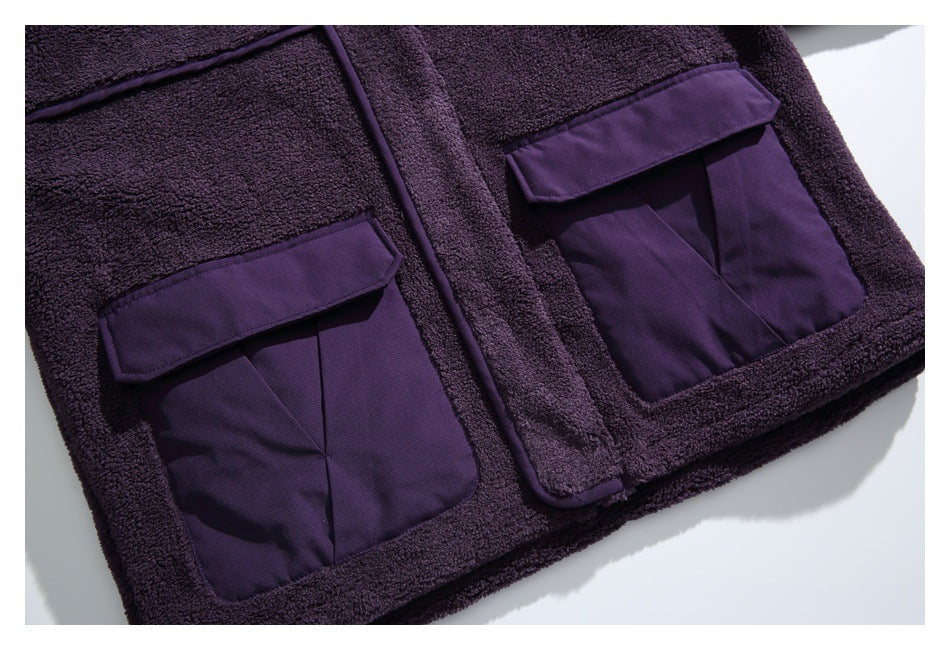 Close view of two large purple flap pockets on the dark purple fleece jacket front.