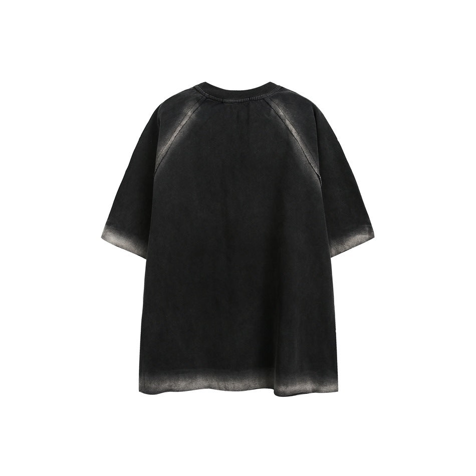 Back of a black oversized short-sleeve raglan shirt with gray fading along the seams, sleeves and hem.