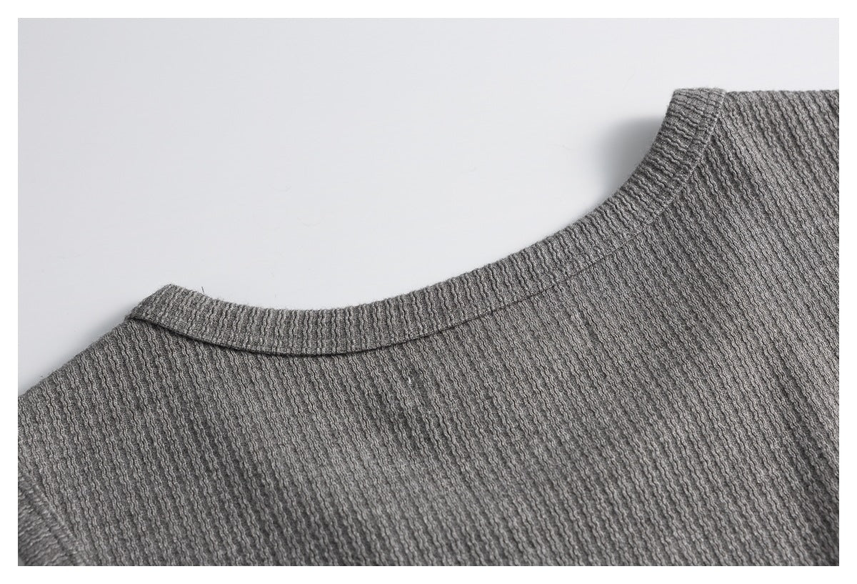 Close-up of the back neckline and textured knit on a gray top.