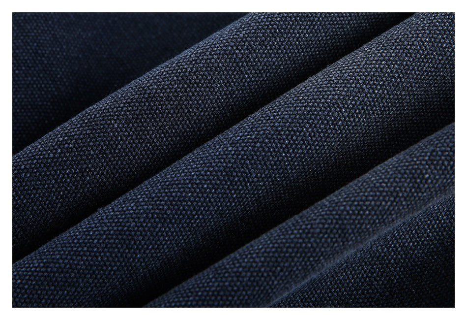 Macro view of dark navy textured fabric arranged in soft folds.