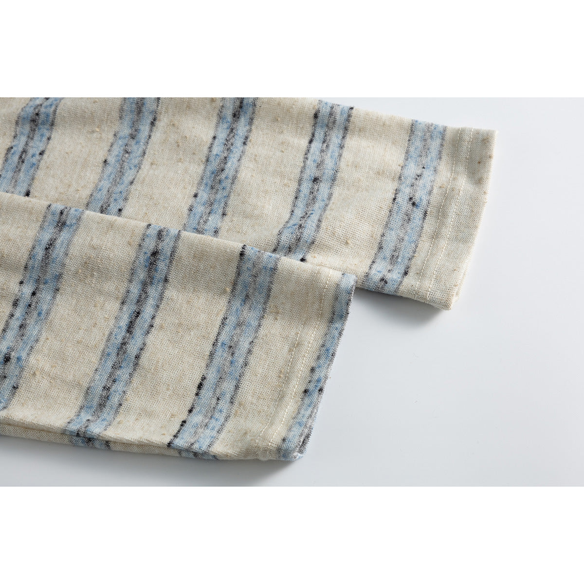 Close-up of the striped top's long sleeve cuffs and hem stitching.