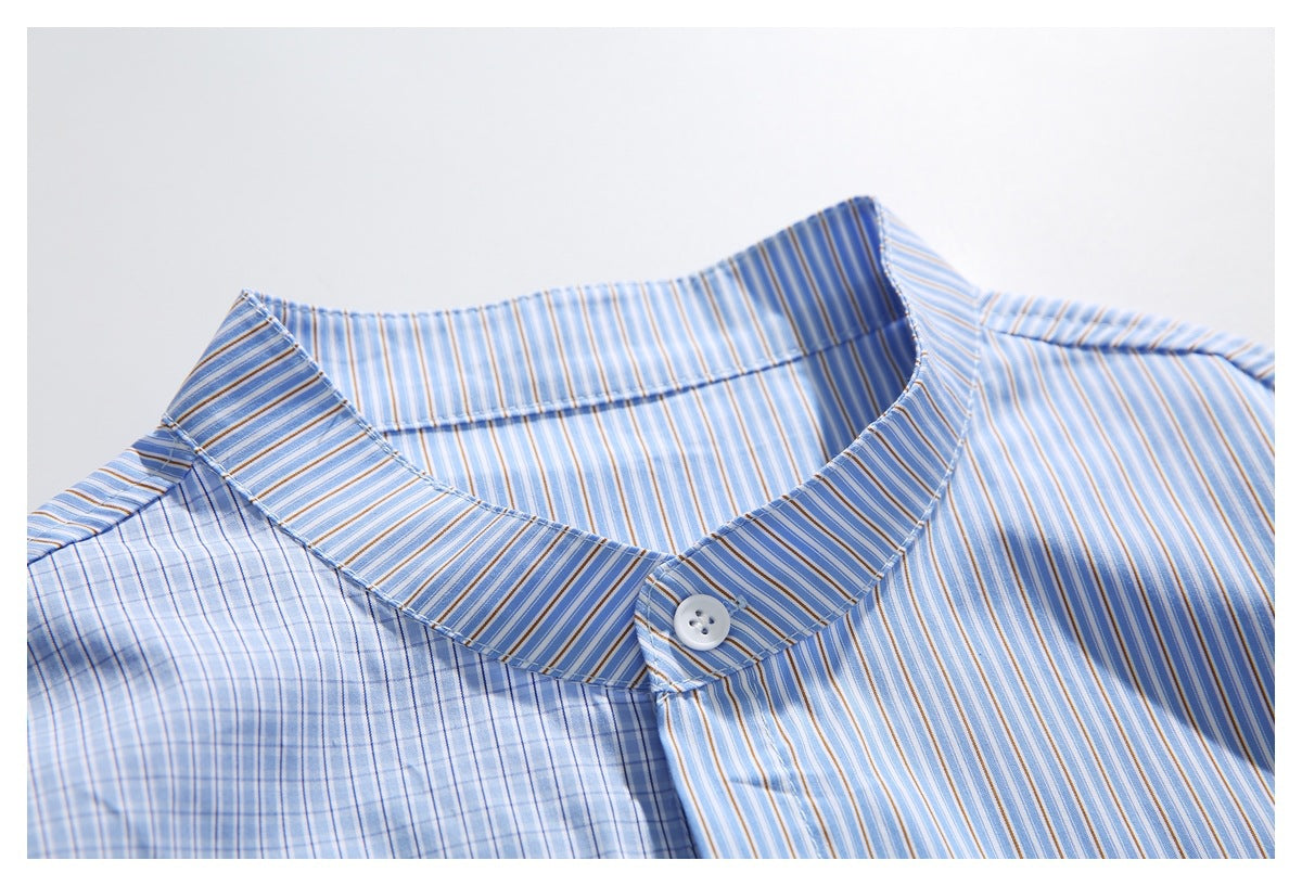 Close-up of the band collar and top button on a blue shirt with mixed stripe patterns.