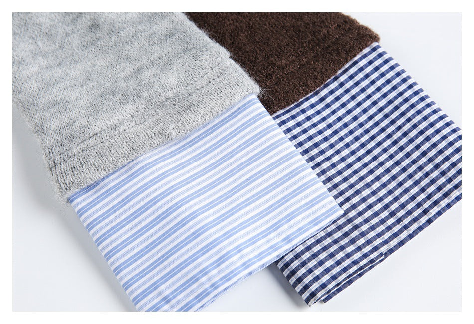 Close-up of gray and brown knit sleeves with striped and blue-and-white checked cuffs.