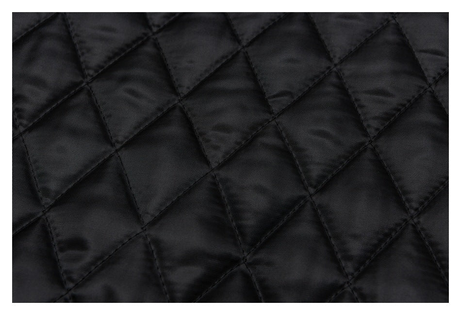 Close-up of black quilted fabric with a diamond-shaped stitched pattern.