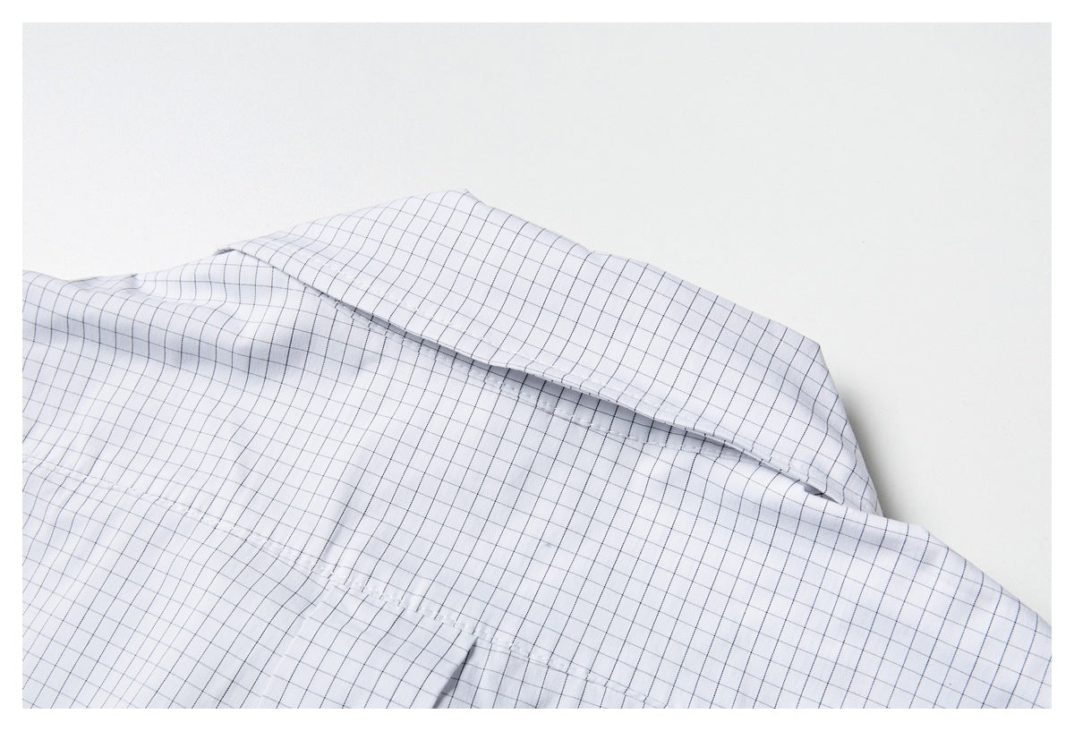 Close-up of the back yoke and collar of a white shirt with a fine gray grid check.