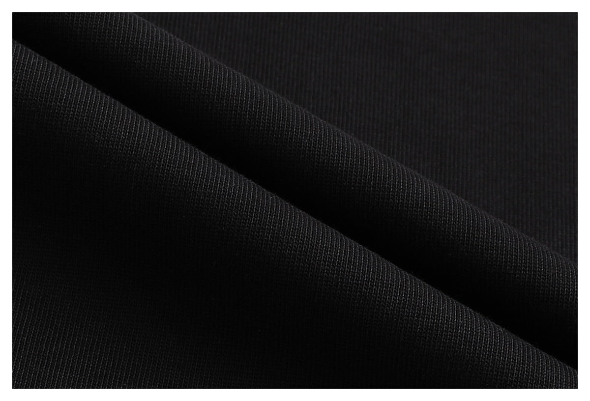 Macro view of black fabric folded to show its fine knit texture.