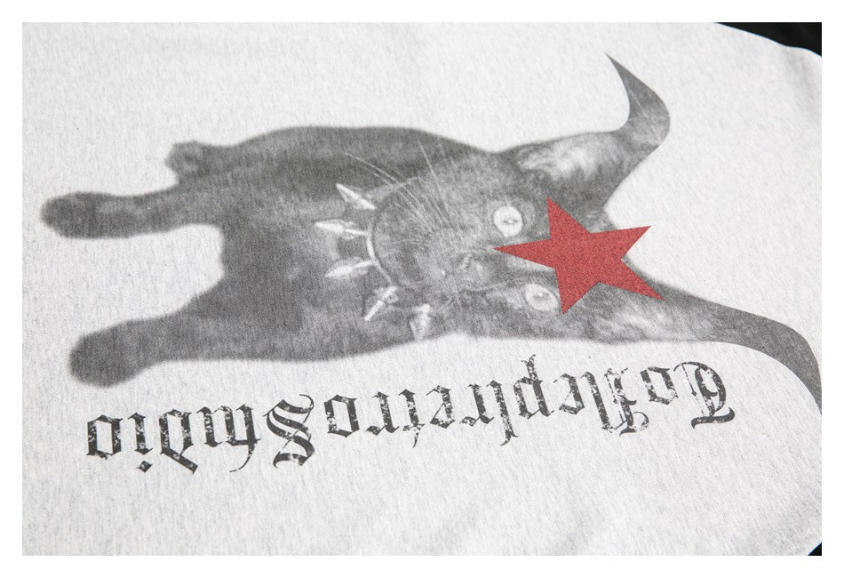 Close-up of a heather-gray shirt graphic with a dark animal face, red star, and upside-down gothic lettering.