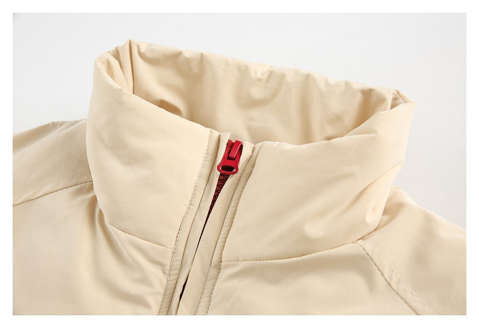 Close-up of the cream jacket's tall collar and red front zipper.