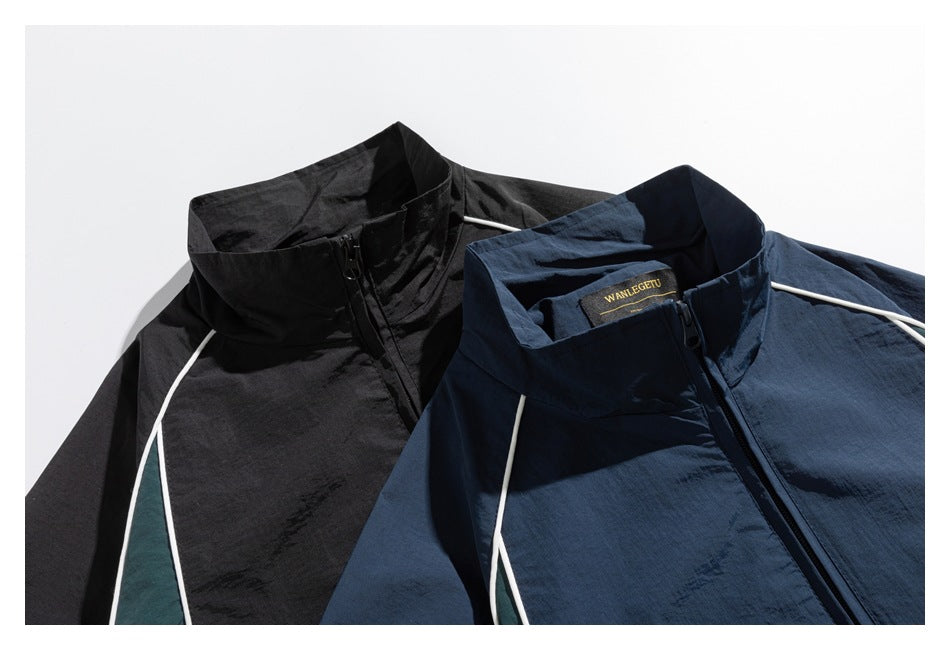 Close-up of black and navy jacket collars and zippers, with contrasting green panels and white piping.