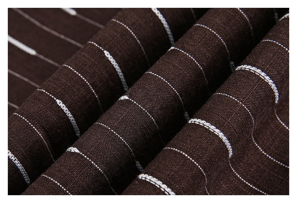 Close-up of dark brown striped fabric gathered into folds, showing thin white lines and thicker broken stripes.