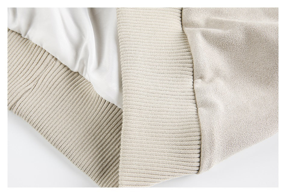 Close-up of the beige jacket's ribbed cuff, smooth lining, and textured outer fabric.