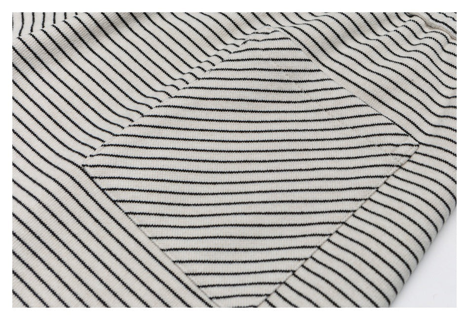 Close-up of a pocket on cream pants with narrow black stripes, showing its stitching and placement.