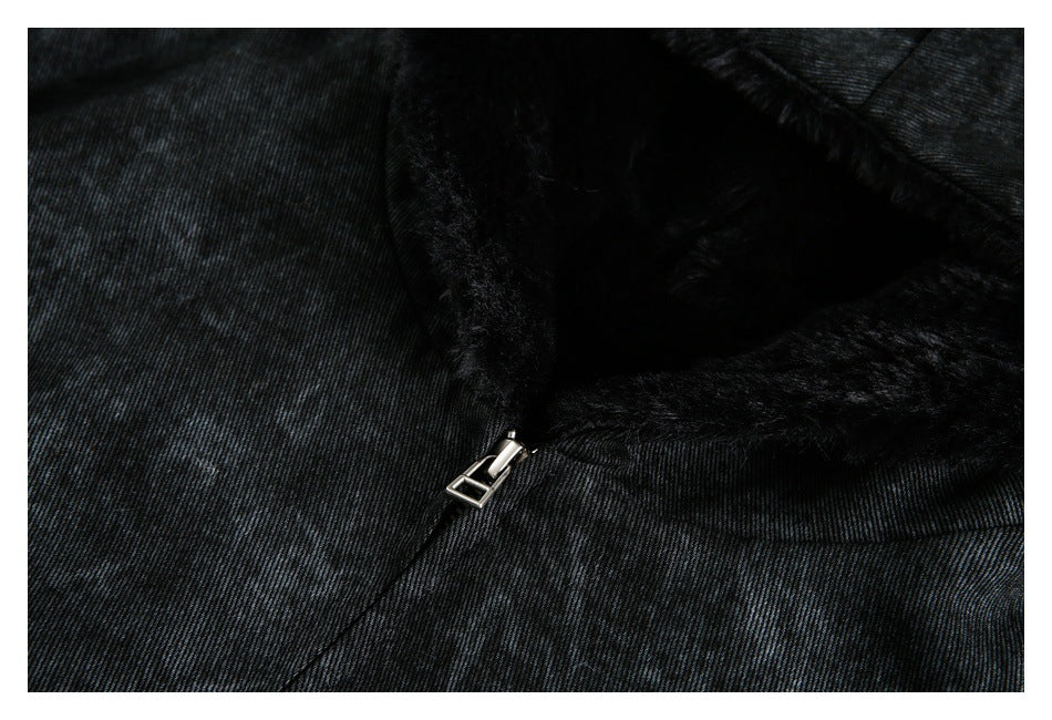 Close-up of the jacket's metal zipper pull beside the dark fuzzy lining and mottled fabric.