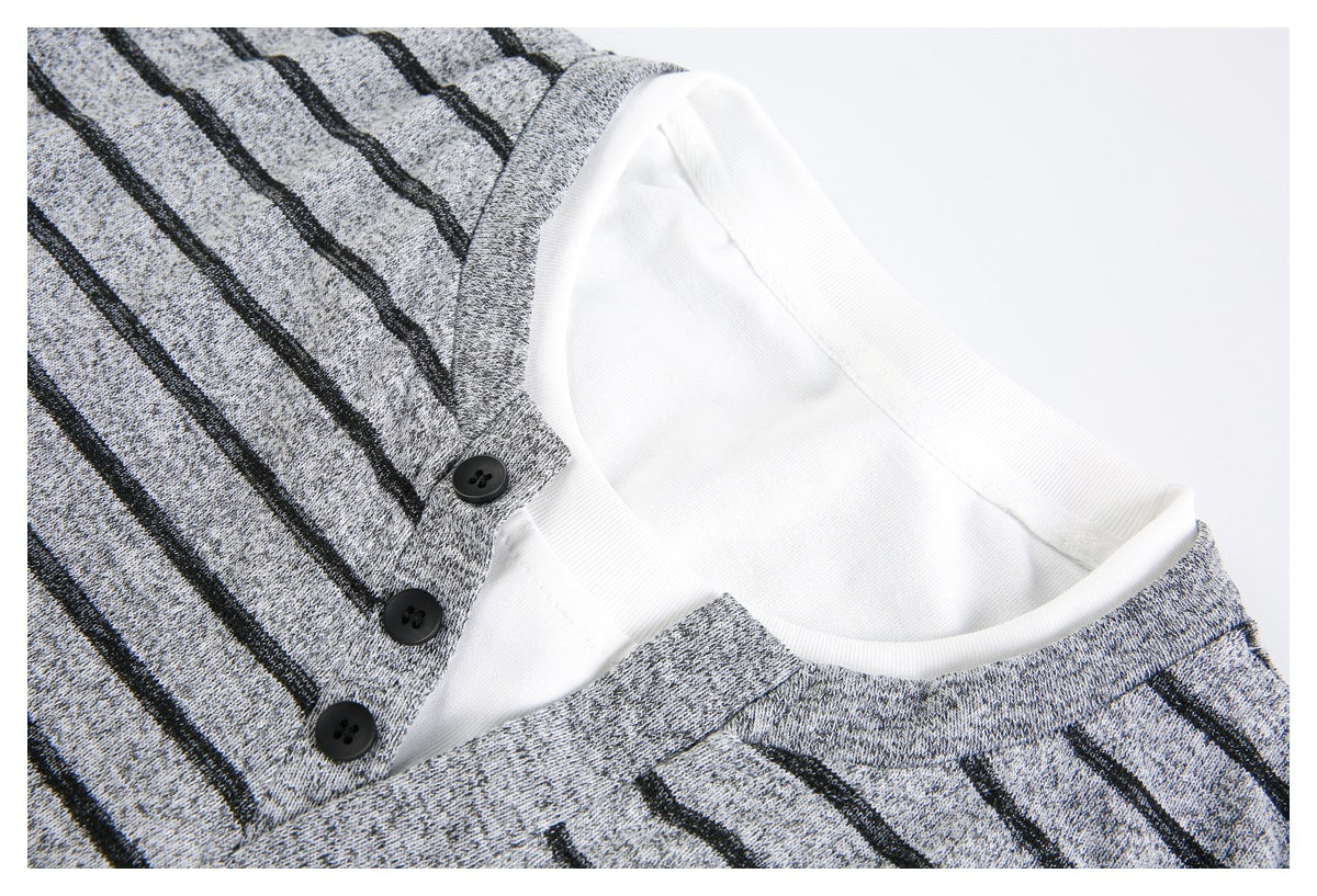 Close-up of a gray-and-black striped Henley neckline with three black buttons and a white inner layer.