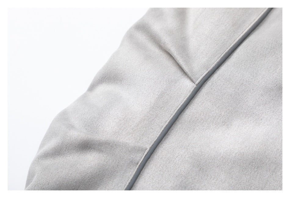Close-up of a light gray jacket sleeve and seam with dark piping.