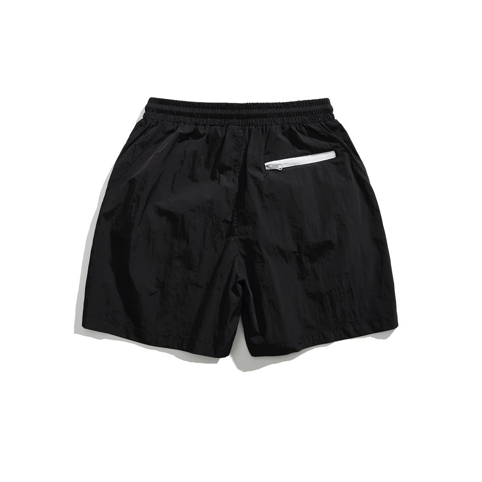 Back view of black shorts with an elastic waistband and white zip pocket.
