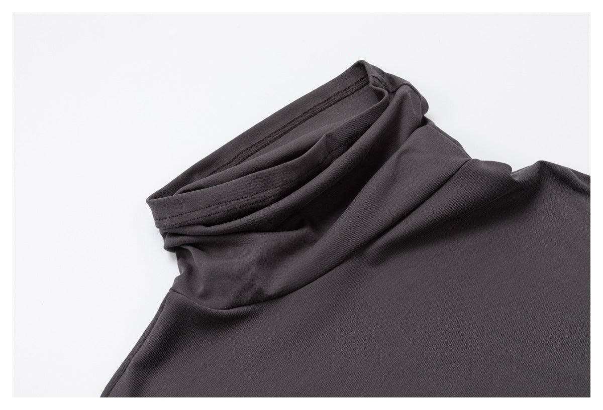 Close-up of a charcoal high-neck top showing the folded neckline and stitching.