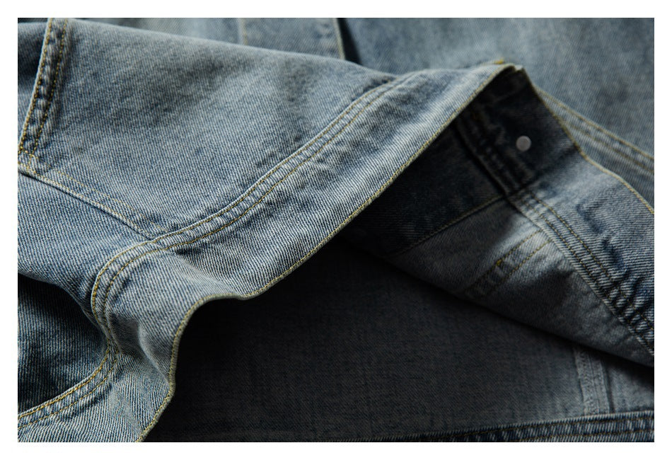 Close-up of a blue denim jacket opened to show its dark interior and stitched seams.