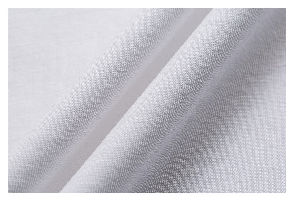 Close-up of light gray-white fabric showing a fine knit texture and soft folds.