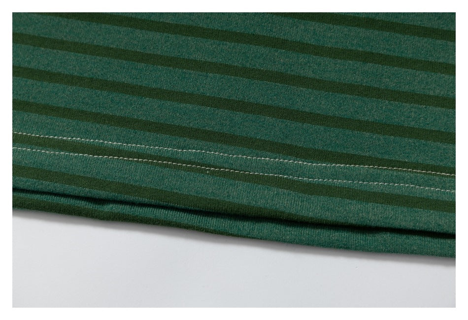 Close-up of green striped fabric showing a double-stitched hem.