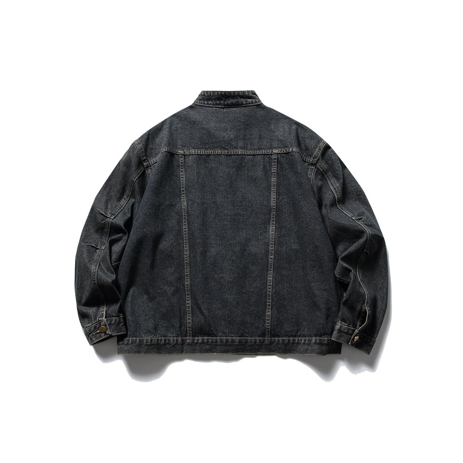 Back of a black washed-denim jacket shown flat, with a high collar, panel seams and buttoned cuffs.