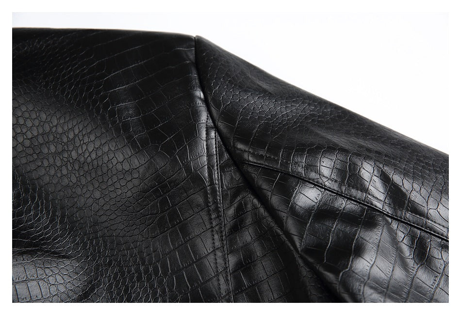 Close-up of a seam joining glossy black crocodile-embossed garment panels.
