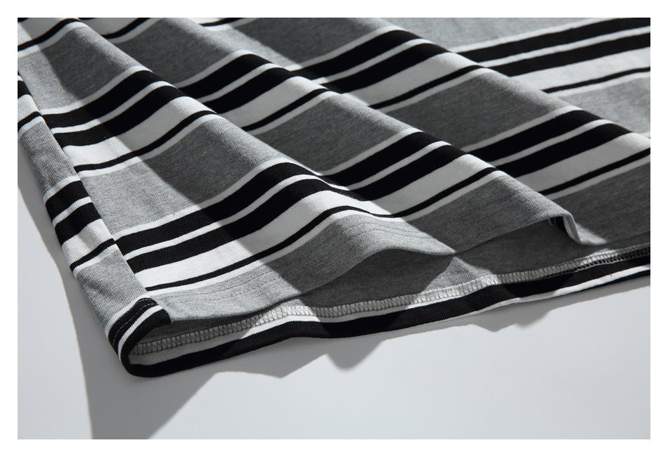 Close-up of the hem and stitched edge of a gray, black, and white striped knit garment.