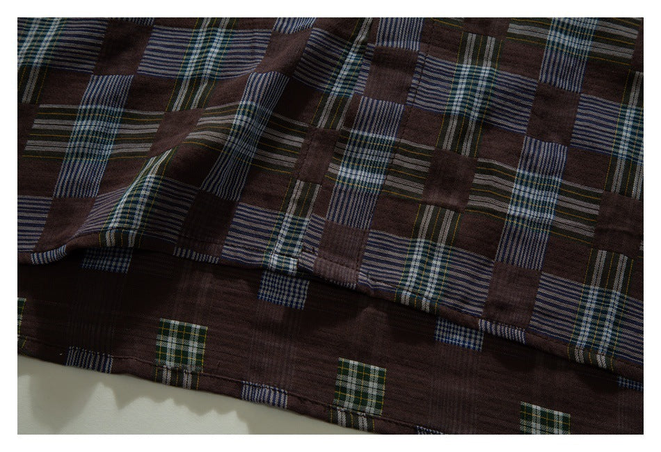 Close-up of the brown patchwork-plaid shirt's lower fabric and stitched hem.