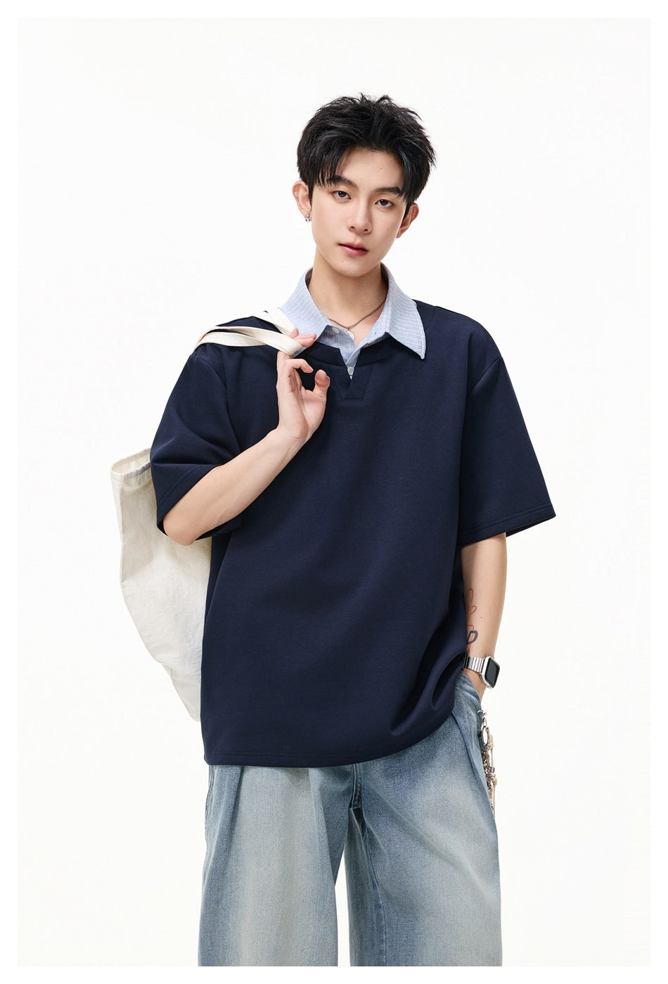 Model in a navy short-sleeve top with a light blue striped layered collar, tote bag over the shoulder