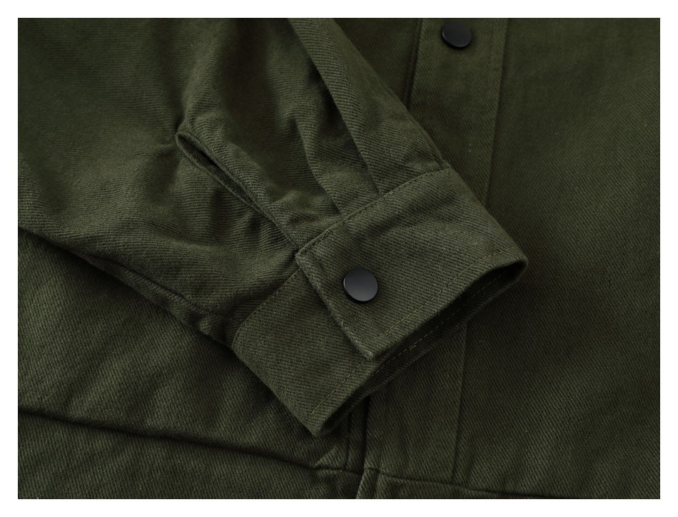 Close-up of a dark olive sleeve cuff with a black snap, beside the garment's front placket.