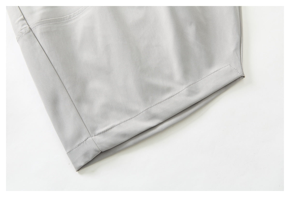 Close-up of a light gray trouser leg and its stitched hem.