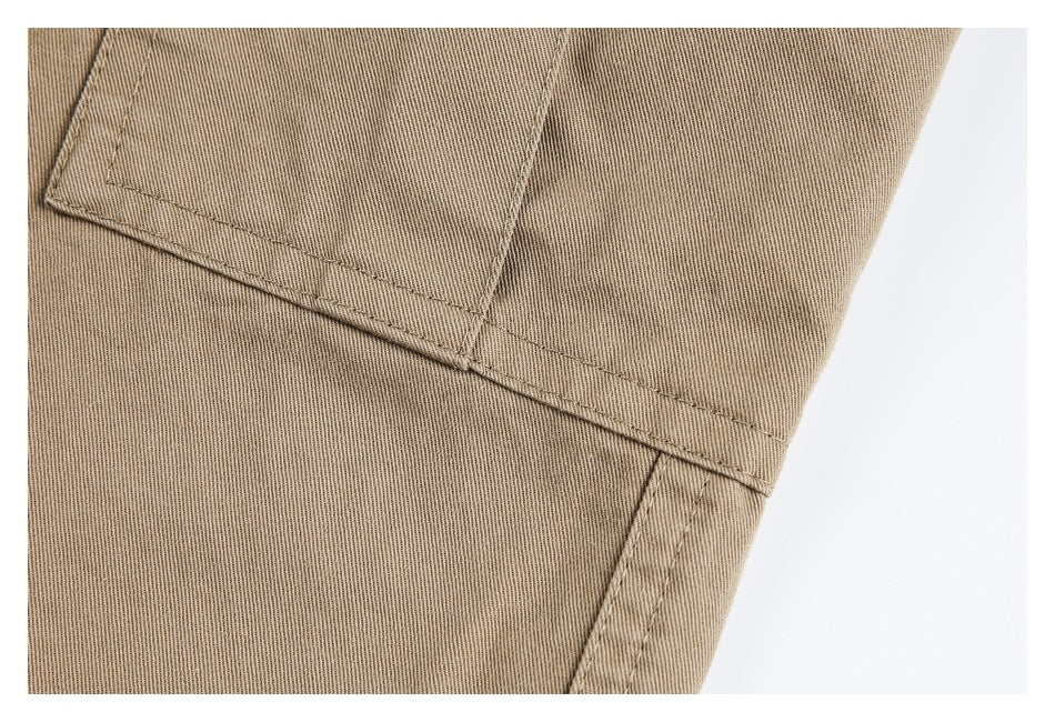 Close-up of stitched seams and pocket construction on khaki pants.