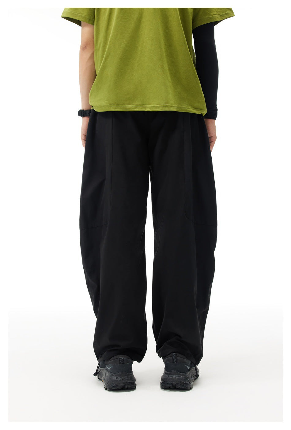 Rear view of a model wearing plain black wide-leg pants.