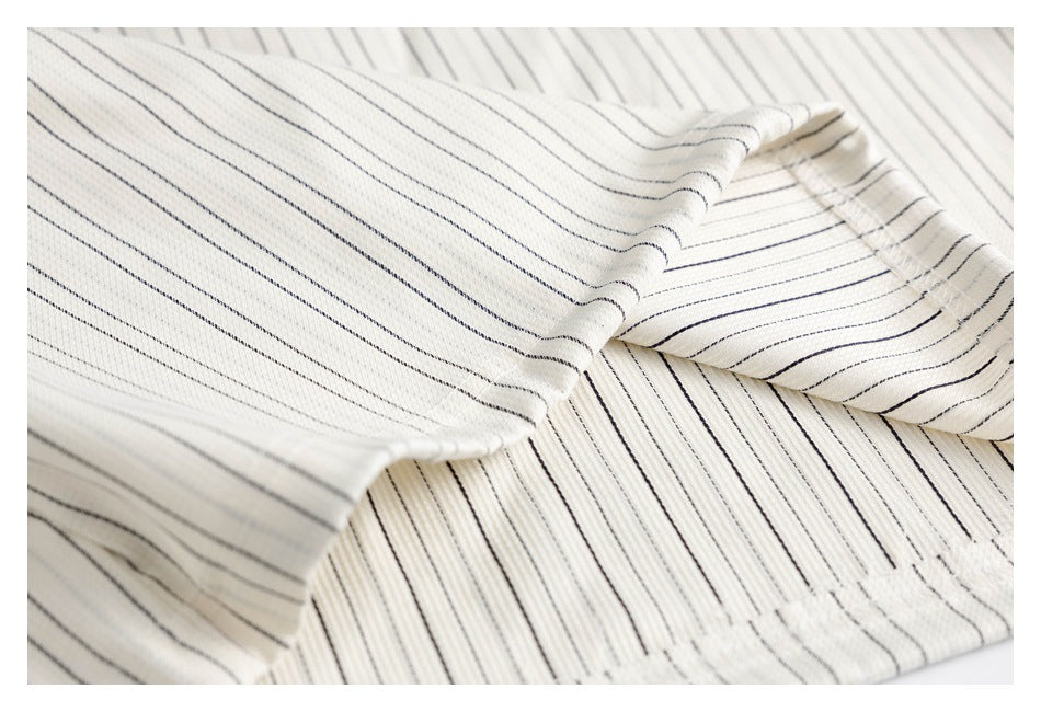Close-up showing the ivory garment's thin dark pinstripes and folded, stitched fabric construction.