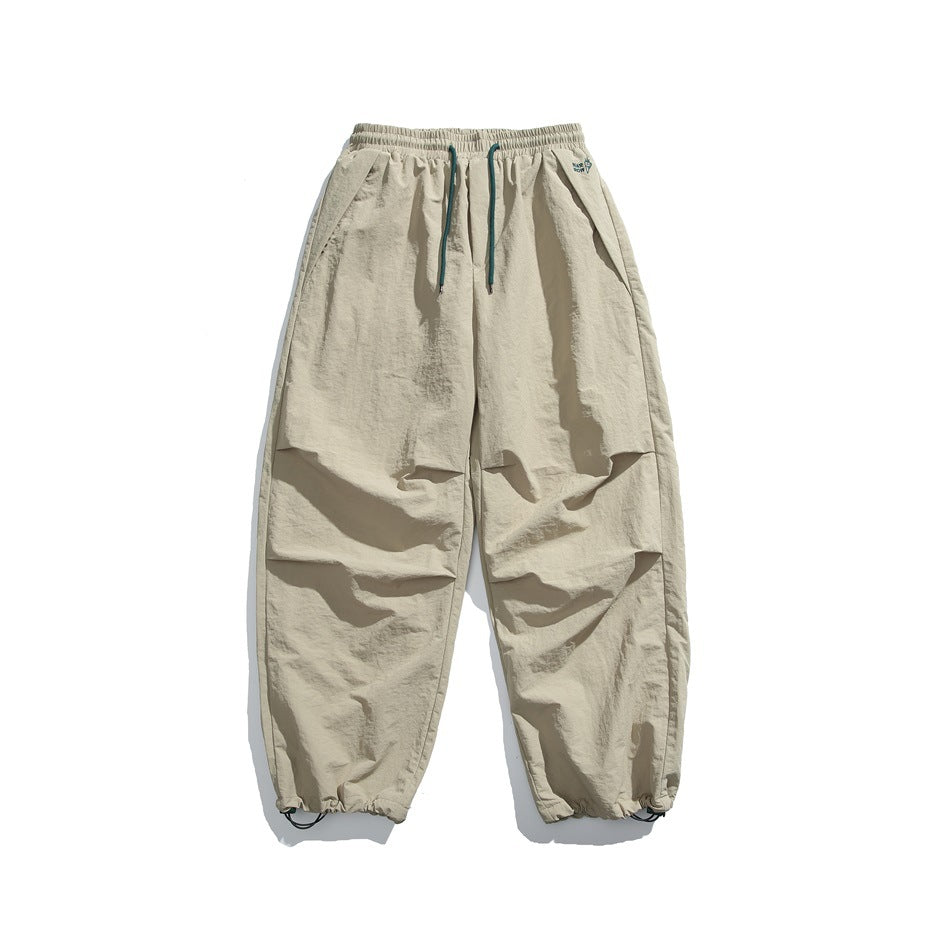 Khaki wide-leg drawstring pants with pleated knees and drawcord hems, flat lay front view