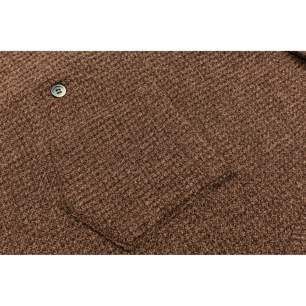 Close-up of brown knit fabric with a small light-colored button.
